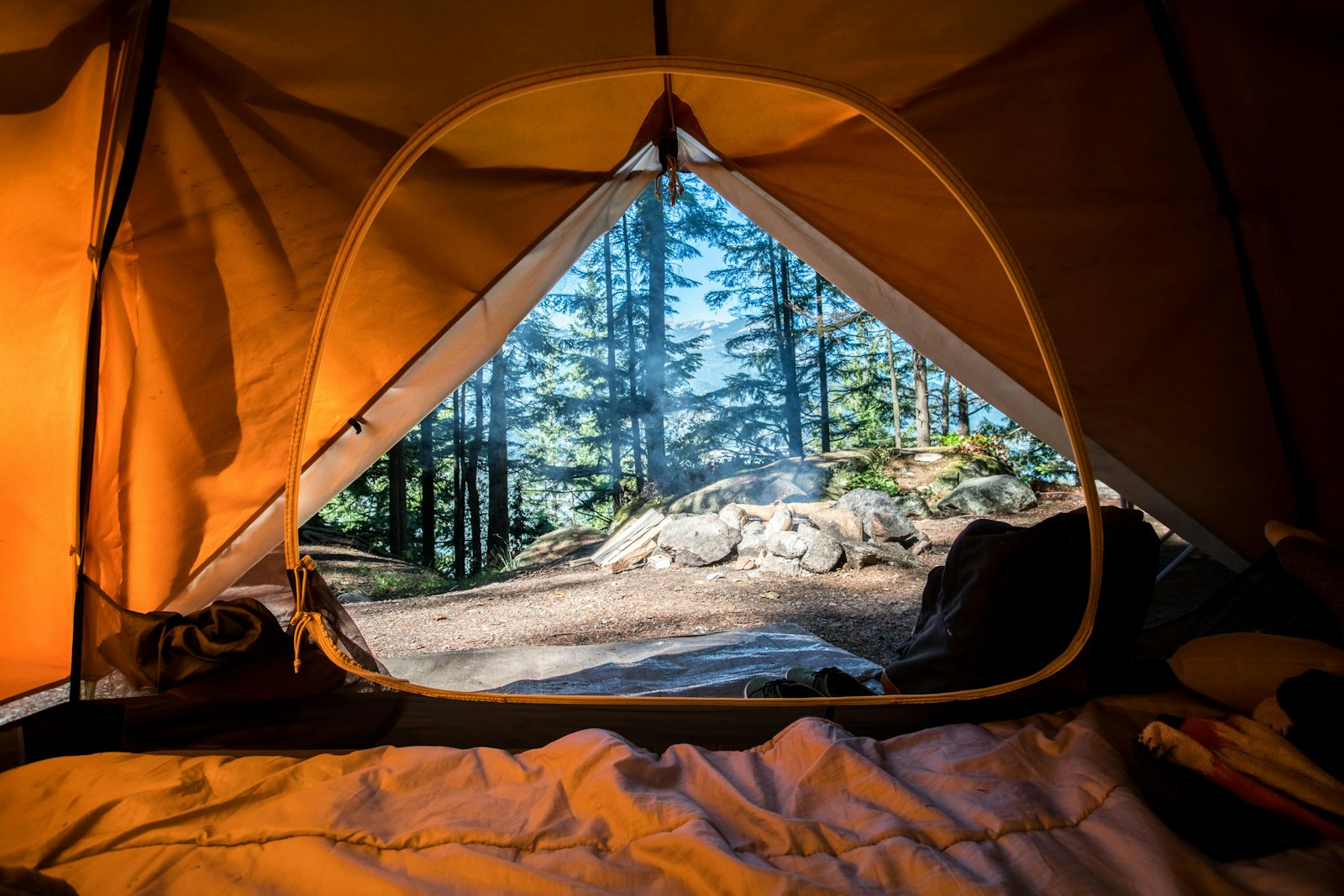 Glowing camping tent under a starry mountain sky
