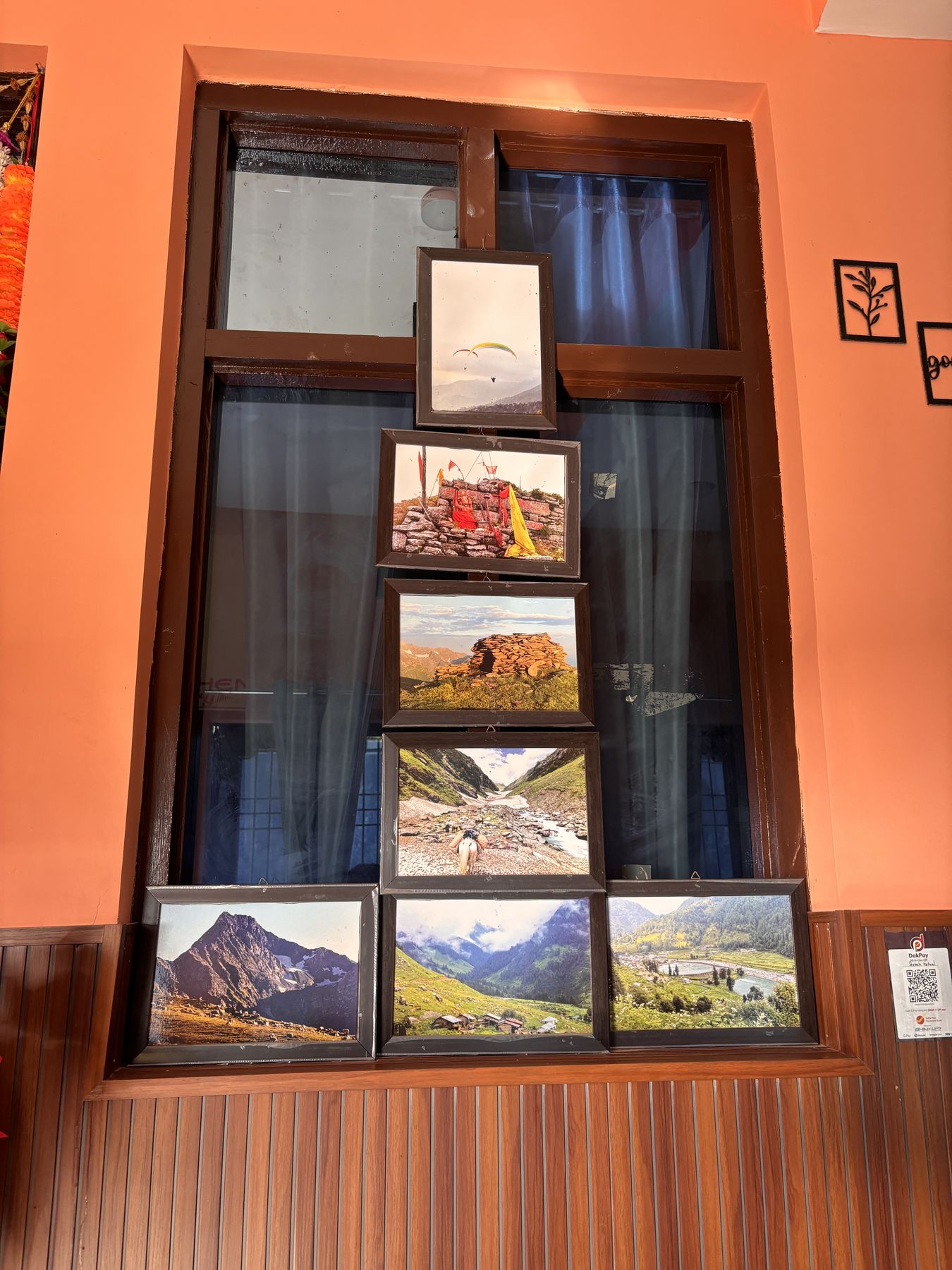 Framed photographs of the mountains displayed in the shop window