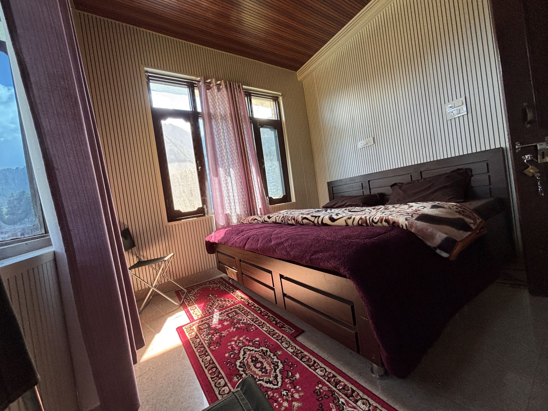 Double bed under a sloping wooden ceiling