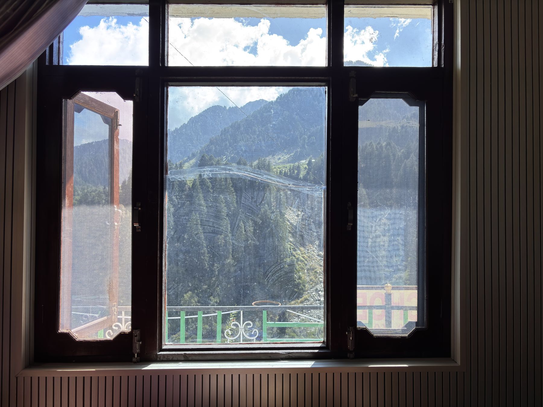 Mountain view framed by a wooden guest room window